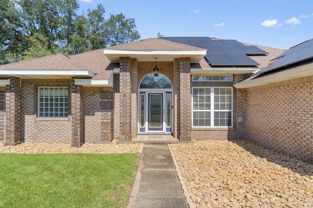 view of front facade with a front yard and solar panels