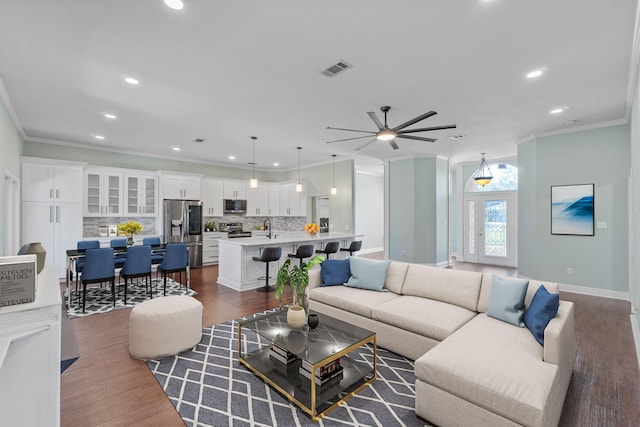 living room with ornamental molding, sink, dark hardwood / wood-style floors, and ceiling fan