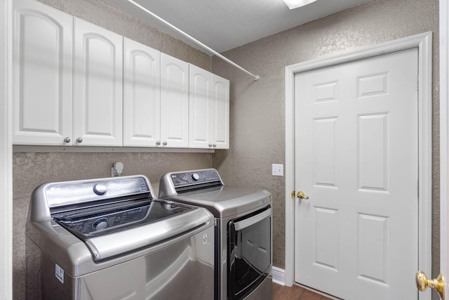 washroom with cabinets, dark hardwood / wood-style floors, a textured ceiling, and separate washer and dryer