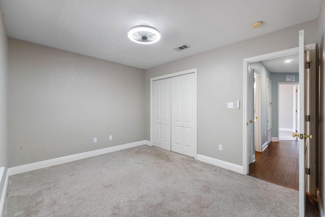 unfurnished bedroom featuring carpet flooring and a closet