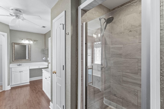 bathroom with vanity, an enclosed shower, hardwood / wood-style floors, and ceiling fan