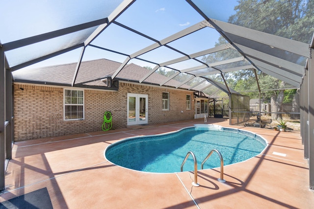 view of pool with a patio area and glass enclosure