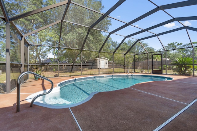 view of swimming pool featuring a patio, a storage unit, and glass enclosure