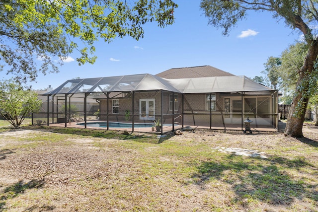 back of house with glass enclosure, a patio, and a fenced in pool