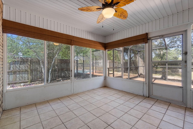 unfurnished sunroom featuring ceiling fan and plenty of natural light