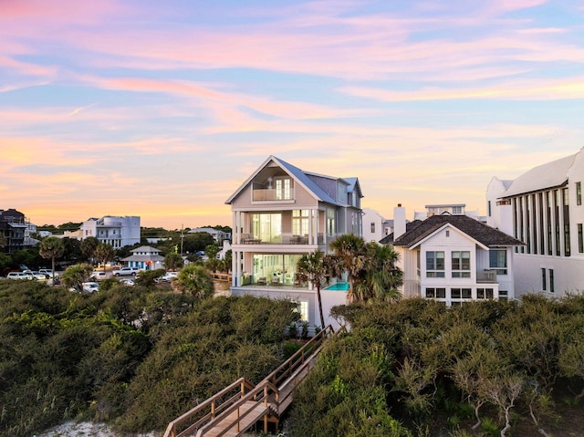 back house at dusk featuring a balcony