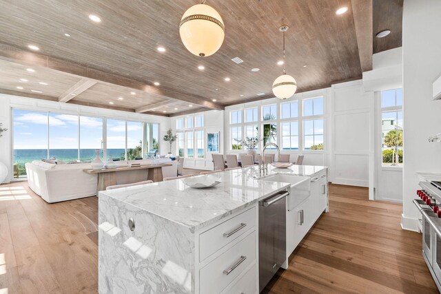 kitchen featuring a center island with sink, plenty of natural light, white cabinetry, and light hardwood / wood-style flooring