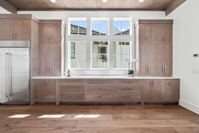 bar featuring wood ceiling, built in fridge, and hardwood / wood-style floors