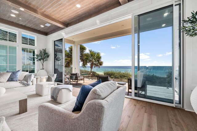 sunroom featuring wooden ceiling, beam ceiling, a water view, and a wealth of natural light