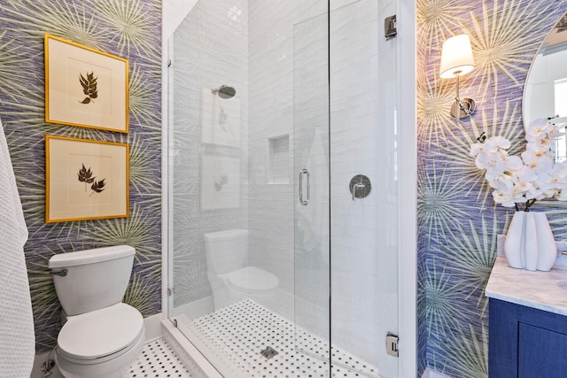 bathroom featuring vanity, toilet, and a shower with door