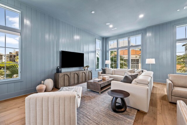 living room featuring light wood-type flooring and wood walls