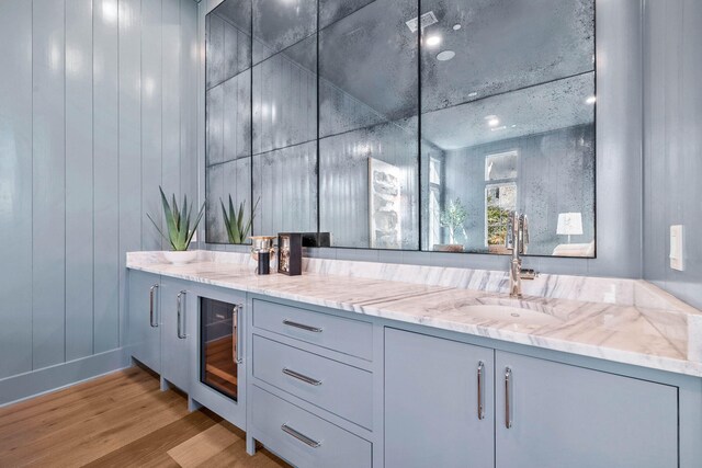 bathroom with wine cooler, hardwood / wood-style flooring, and vanity