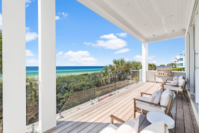 wooden deck featuring a beach view, a grill, and a water view