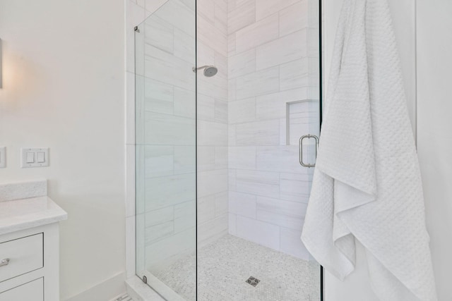 bathroom featuring vanity and a shower with door