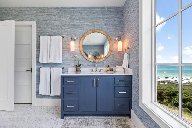 bathroom with a view of the beach, a water view, and vanity