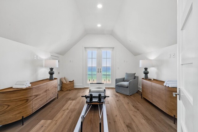 interior space featuring light wood-type flooring, a water view, and vaulted ceiling