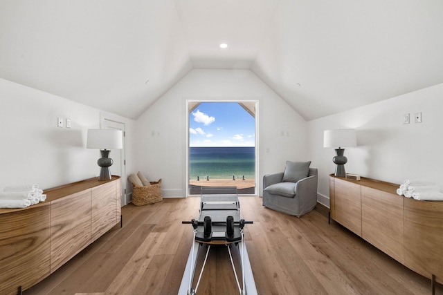 bedroom with a water view, vaulted ceiling, and light hardwood / wood-style floors