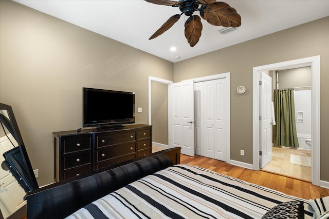 bedroom featuring light wood-type flooring, connected bathroom, ceiling fan, and a closet