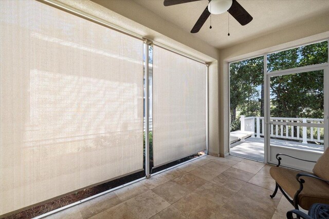 unfurnished sunroom with ceiling fan