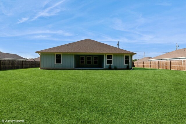 rear view of property with a yard