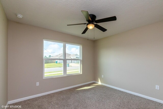 carpeted spare room featuring a textured ceiling and ceiling fan