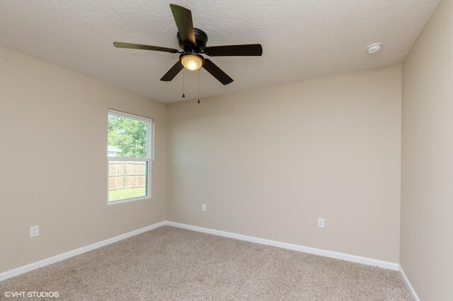 spare room with light carpet, ceiling fan, and a textured ceiling