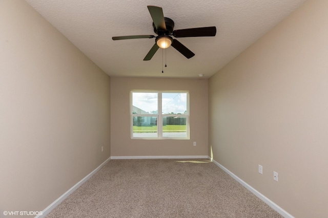 carpeted spare room featuring ceiling fan and a textured ceiling