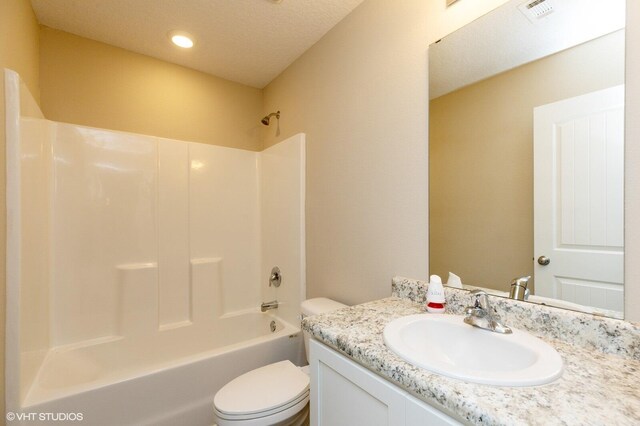 full bathroom with shower / washtub combination, a textured ceiling, vanity, and toilet