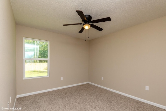 carpeted spare room featuring ceiling fan and a textured ceiling