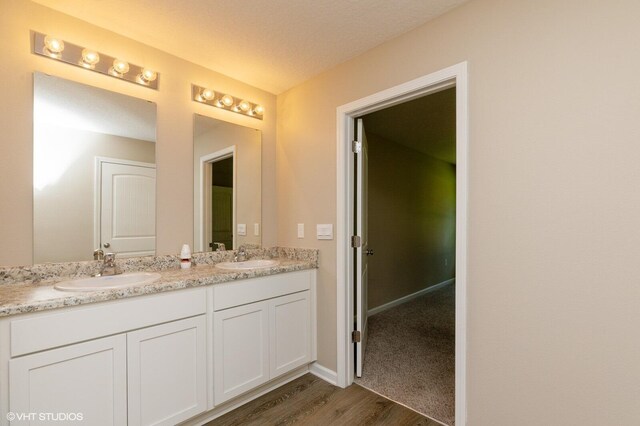 bathroom featuring a textured ceiling, wood-type flooring, and vanity