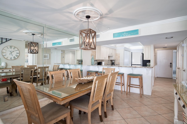 tiled dining space with a notable chandelier and ornamental molding