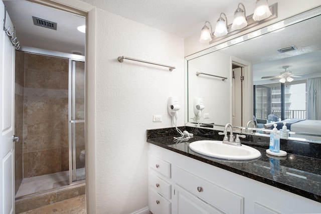 bathroom featuring vanity, ceiling fan, a textured ceiling, and walk in shower