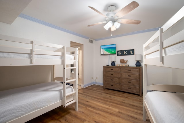 bedroom featuring ceiling fan, ornamental molding, and hardwood / wood-style floors