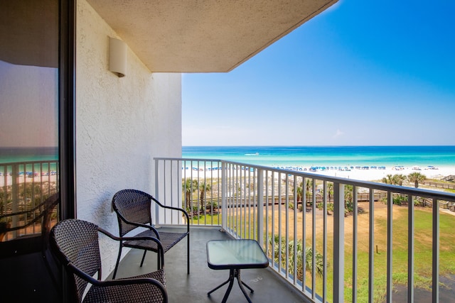 balcony with a water view and a beach view