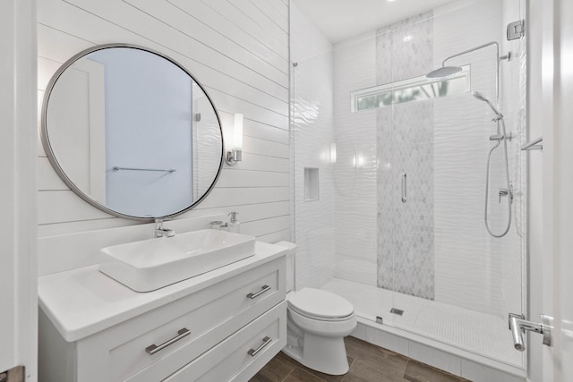 bathroom with wooden walls, walk in shower, vanity, and toilet