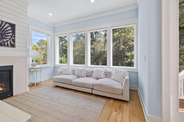 living room with light wood-type flooring and ornamental molding