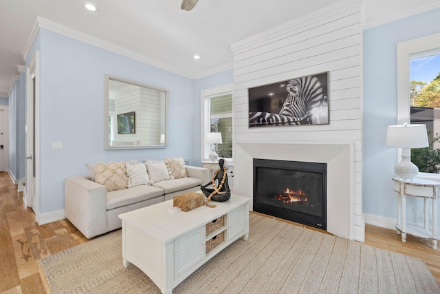 living room featuring light wood-type flooring and ornamental molding