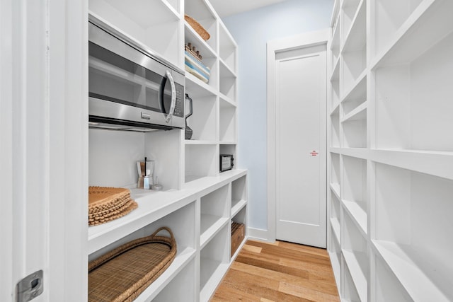 spacious closet with light hardwood / wood-style flooring