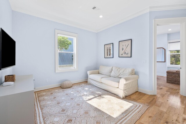 sitting room with crown molding and light hardwood / wood-style floors