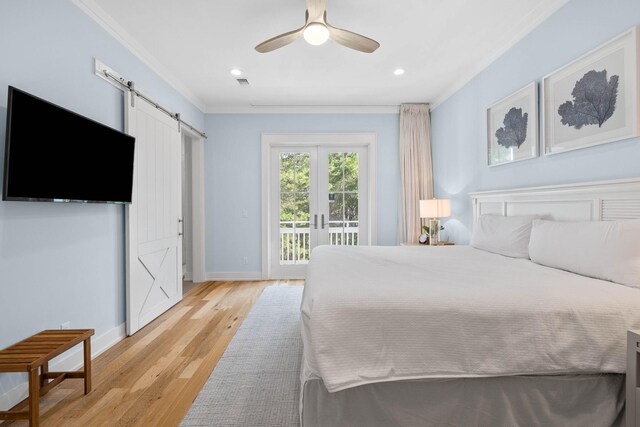 bedroom featuring light hardwood / wood-style floors, a barn door, ceiling fan, access to outside, and ornamental molding