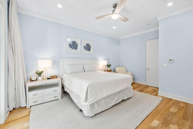 bedroom with ornamental molding, ceiling fan, and light hardwood / wood-style flooring