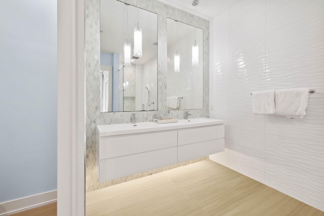 bathroom featuring tile walls, hardwood / wood-style flooring, and vanity