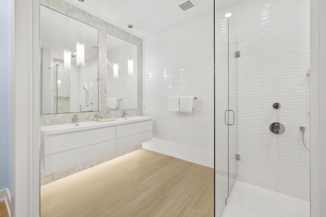 bathroom featuring walk in shower, vanity, tile walls, and hardwood / wood-style floors