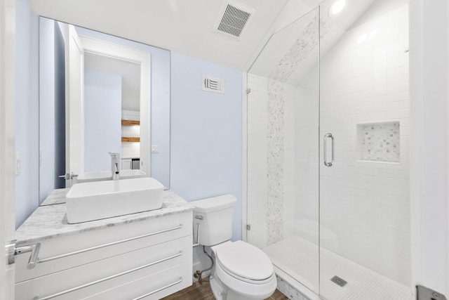 bathroom featuring vanity, toilet, hardwood / wood-style floors, an enclosed shower, and vaulted ceiling