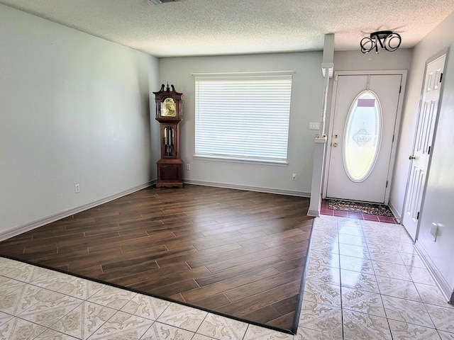 foyer entrance with a textured ceiling and hardwood / wood-style flooring