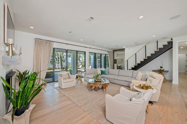 living room featuring light hardwood / wood-style flooring, a fireplace, and french doors