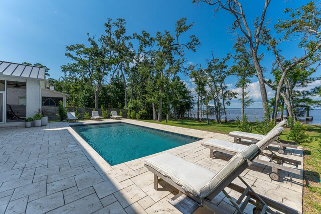 view of swimming pool with a water view and a patio area