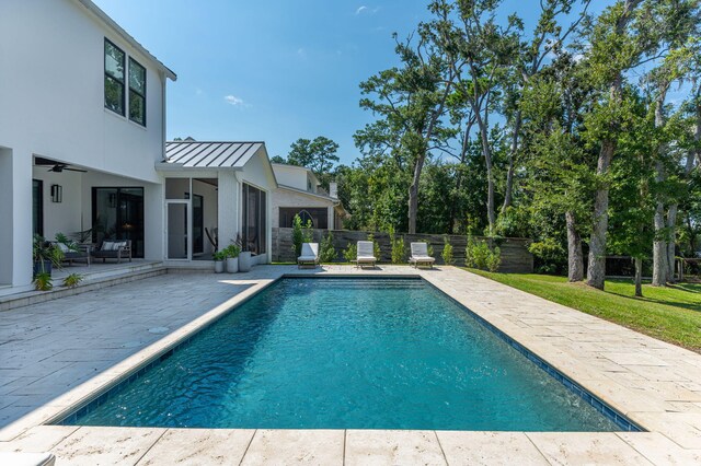 view of swimming pool featuring ceiling fan and a patio area