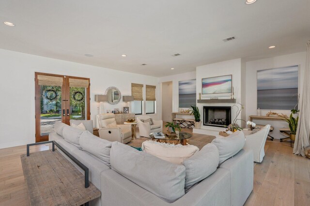 living room featuring french doors and light wood-type flooring