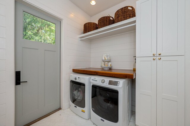 washroom with independent washer and dryer and cabinets